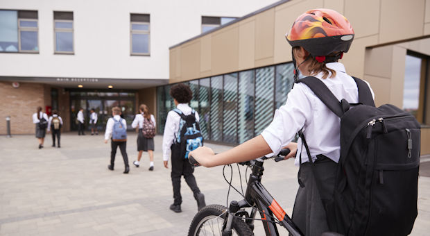 Child pushing a bike to school
