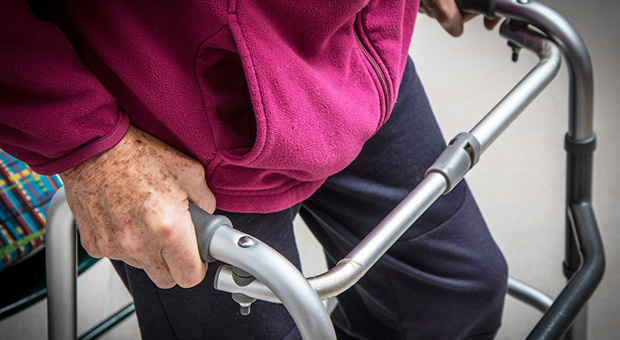 Close-up of elderly persons hands holding onto a walking frame
