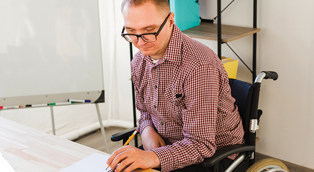 male employee in wheelchair working at a desk