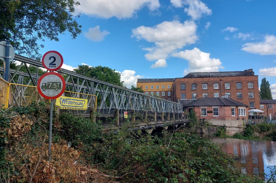 metal footbridge spanning over river.