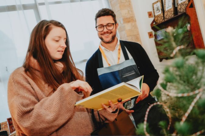 A smiling trader talks to a customer in his shop