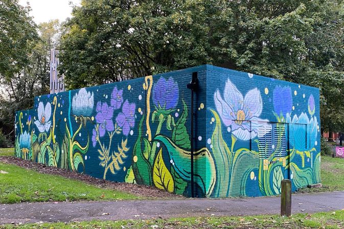 A colourful mural painted on a substation depicting a bold floral design
