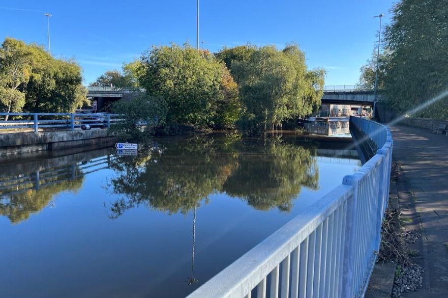 A flooded underpass with car park sign stood above the water.