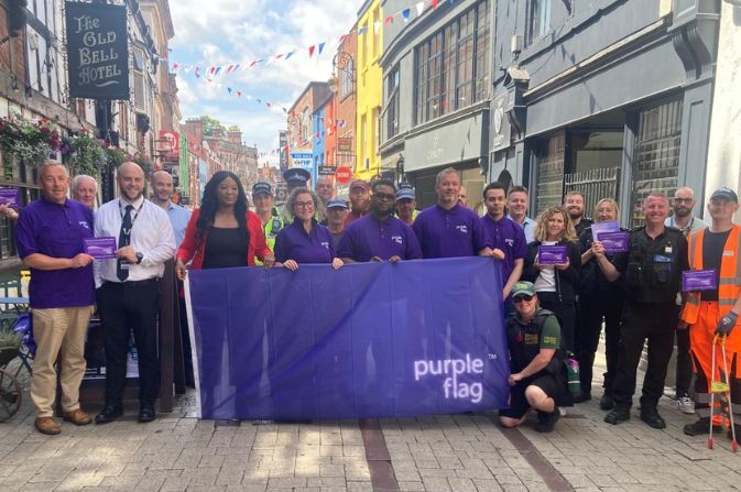 purple flag held up by Councillor Peatfield and partners from Derby organisations