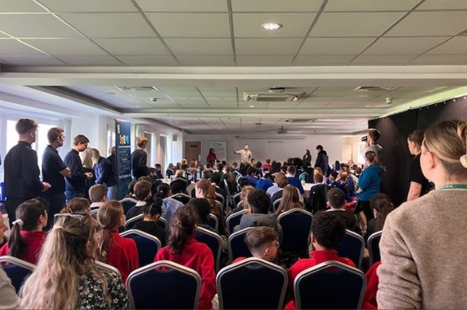 A room full of students seated listening to a presentation