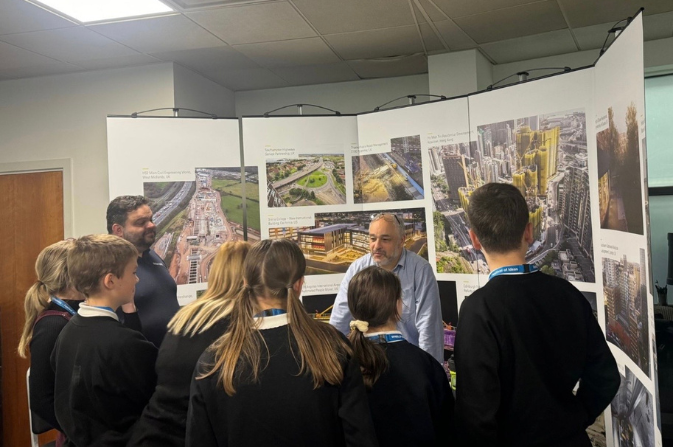 A group of students photographed from behind as they visit a stand at the Festival of Ideas