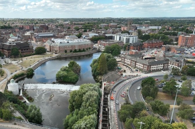 An aerial view of a river with construction works on the right bank.