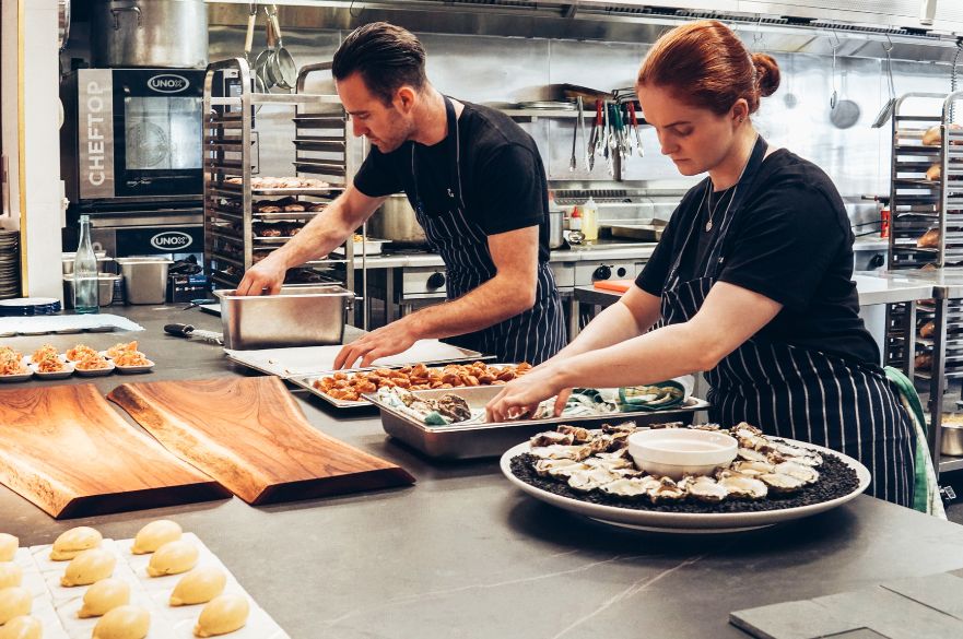 Two chefs in a kitchen preparing food