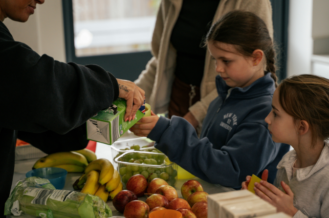 A child gets given a drink at a HAF event