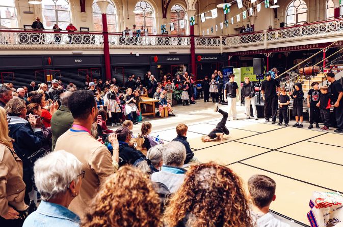 A crowd watches a dance performance inside Derby Market Hall