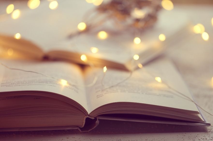 Book open on table with fairy lights 