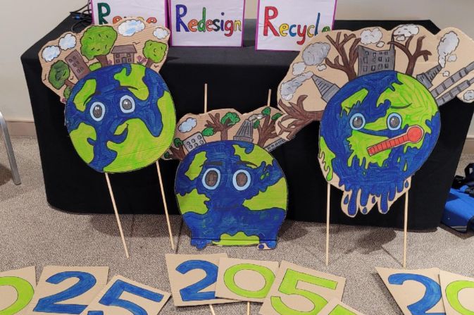 Artwork created by school pupils at the Festival of Ideas including three cartoon planet Earth models