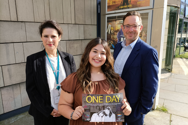 Margita, aged 14, with the poster for the film One Day, alongside Derby City Council's Director of Early Help and Children’s Social Care Suanne Lim and Chief Executive Paul Simpson