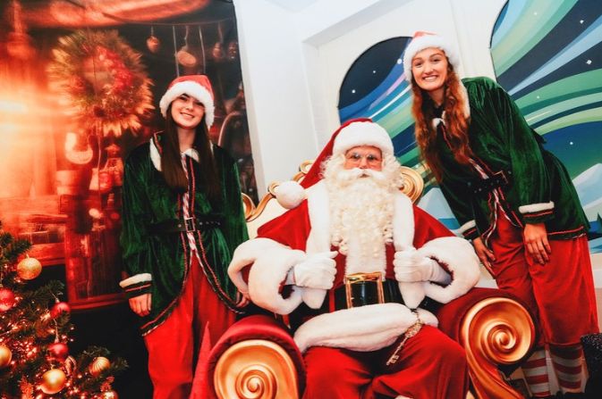 Santa and two of his elves inside his grotto