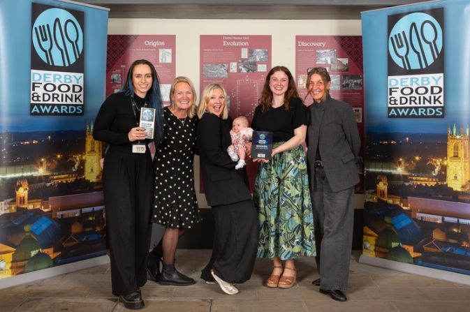 A group of smiling women holding an award for Best Newcomer