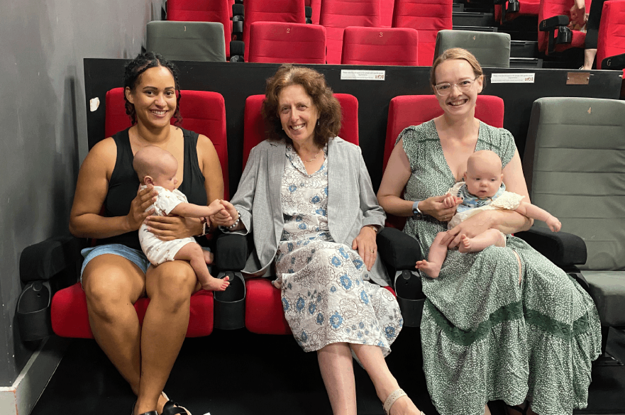 Councillor Alison Martin sitting in cinema seats at the Quad with Holly Mowbray Stammers and baby Murphy, and Kate McCormack with baby Madeline