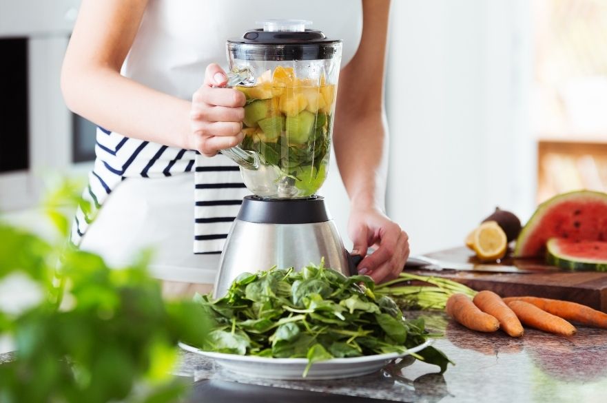 woman making smoothie in blender
