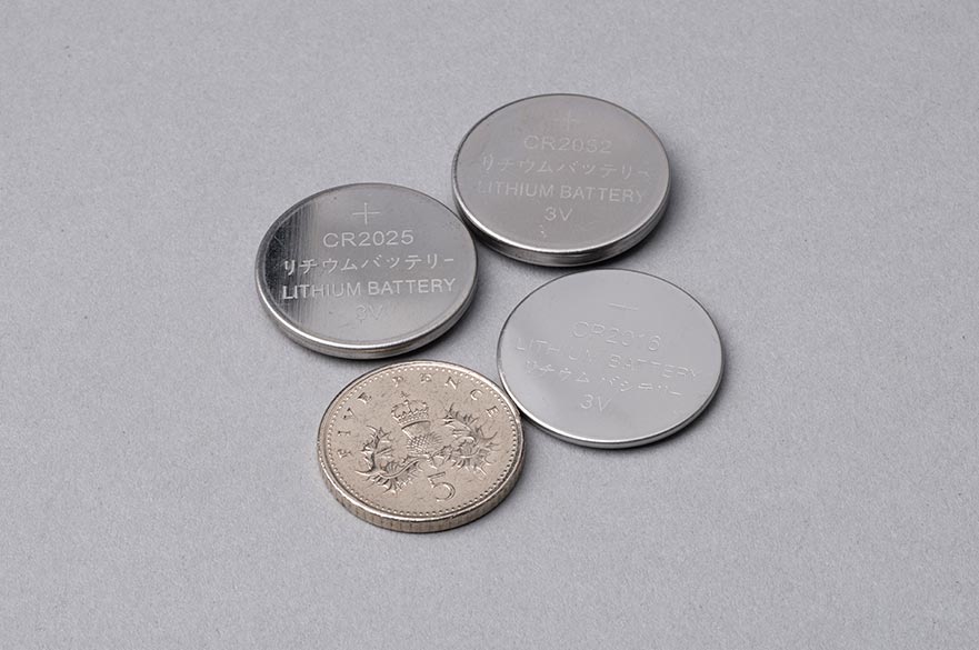 Button batteries next to 5p coin