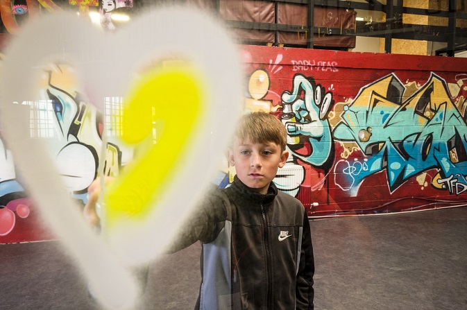 A boy taking part in graffiti with Baby People during HAF