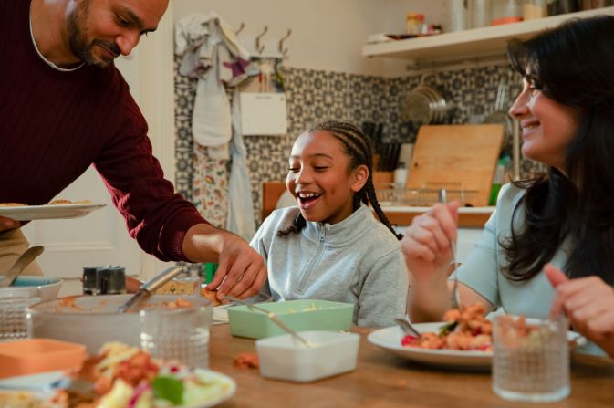 Family enjoying a meal, laughing.