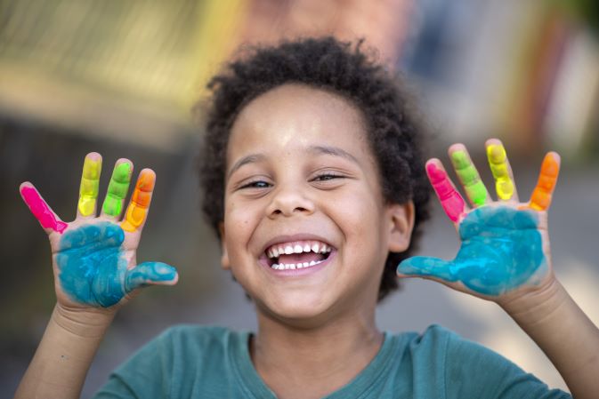 A smiling boy taking part in painting activities