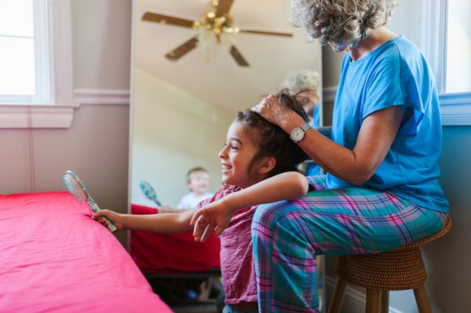 Woman hairstyling a childs hair