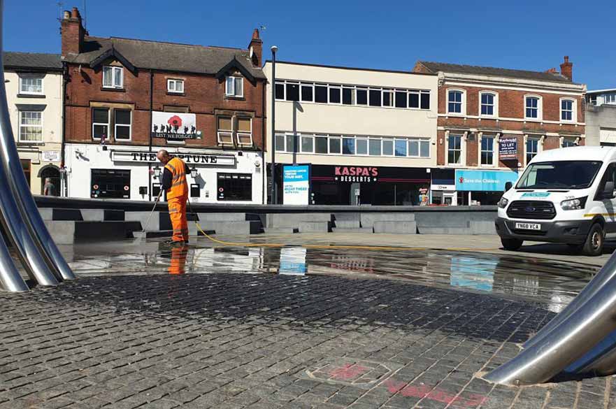 Street cleaner pressure washing pavement