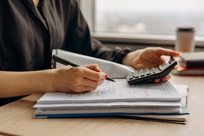 Woman working out sums by using a calculator