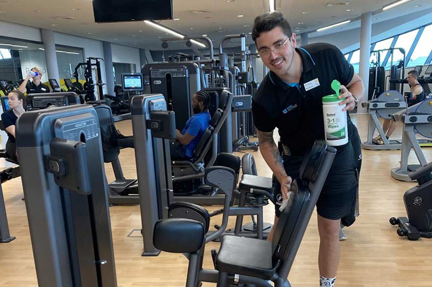 Leisure attendant cleaning gym equipment