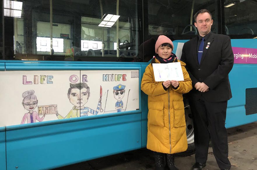 Councillor and child next to bus advert